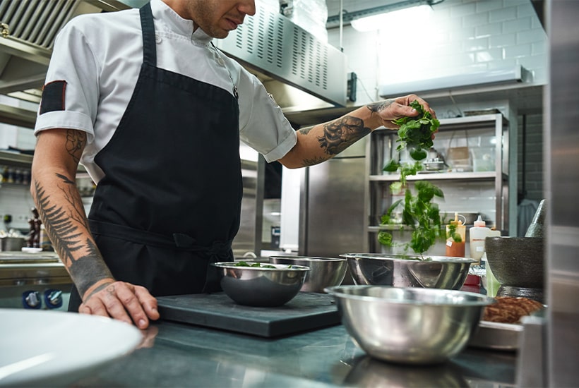 Chef qui prépare des herbes pour un repas