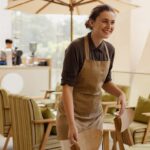 Jeune serveuse souriante qui travaille sur une terrasse de cafétaria